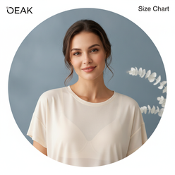 Portrait of Ava Johnson smiling, wearing a cream t-shirt over a wireless bra, against a soft slate blue background.